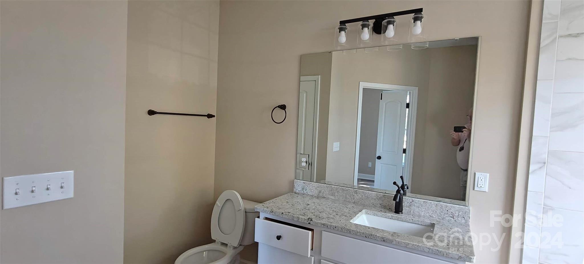 9649 Stokes Ferry Road Gold Hill, NC 28071 - Photo 15 of 17 a bathroom with a granite countertop sink toilet and mirror