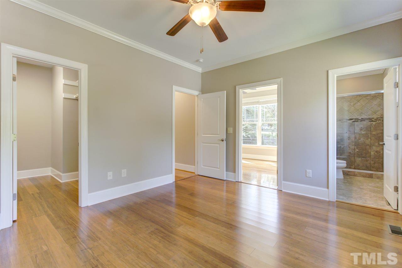 422 Heather Drive Raleigh, NC 27606 - Photo 18 of 30 Primary Bedroom with views into walk in closet, hallway, sun room, and primary bathroom.