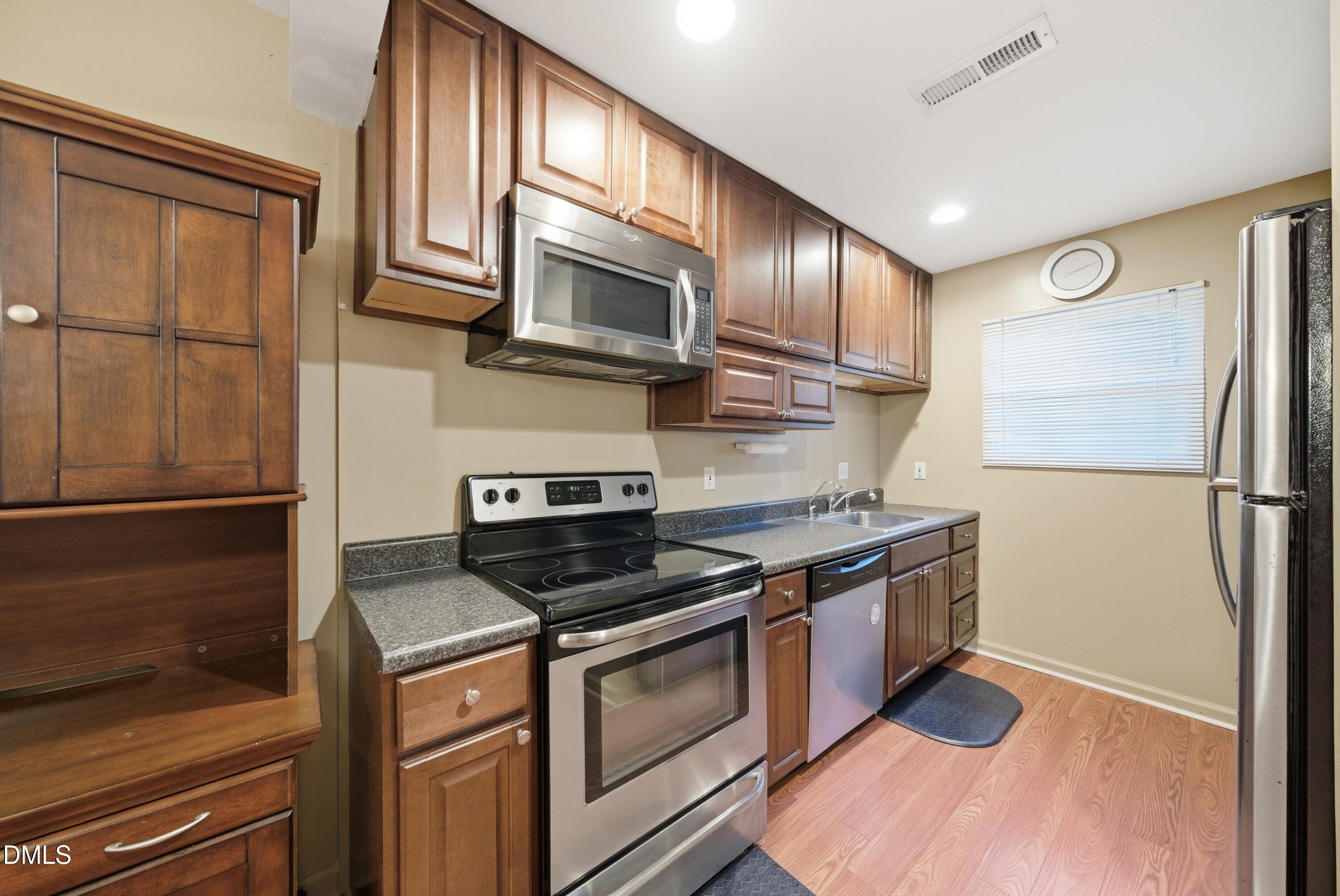 6355 New Market Way Raleigh, NC 27615 - Photo 10 of 30 a kitchen with stainless steel appliances granite countertop a stove a refrigerator and a microwave
