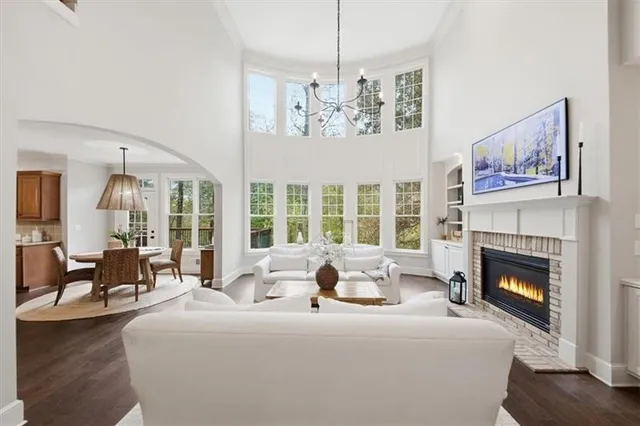 a living room with furniture large windows and a fireplace
