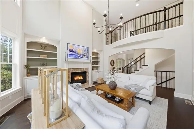 a living room with fireplace furniture and a large window
