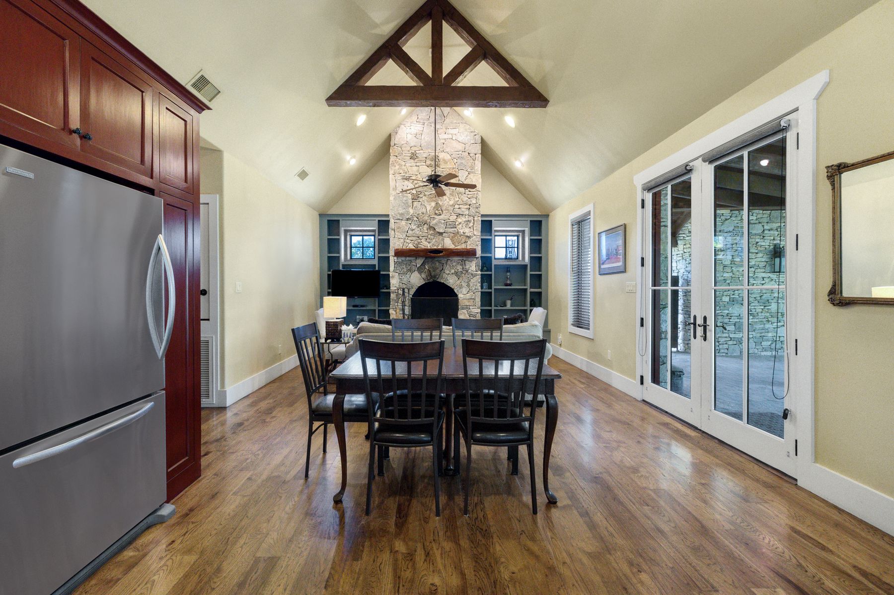 18059 Ranch To Market Road 1826 Buda, TX 78610 - Photo 36 of 39 Dining area featuring a stone fireplace, a high ceiling, built in shelves, dark wood-style flooring, and ceiling fan