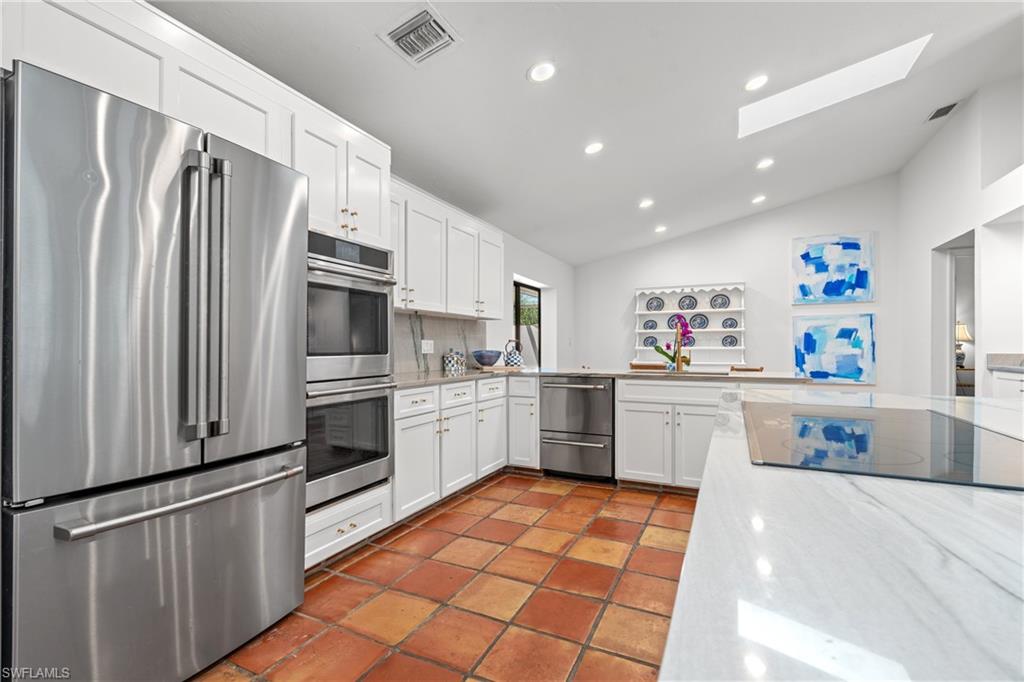 2419 Pinewoods Circle, Unit 11 Naples, FL 34105 - Photo 13 of 32 a kitchen with stainless steel appliances a refrigerator sink and white cabinets