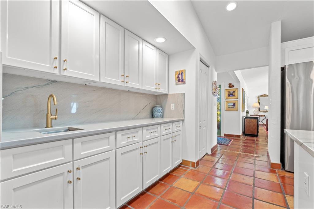 2419 Pinewoods Circle, Unit 11 Naples, FL 34105 - Photo 16 of 32 a kitchen with white cabinets and refrigerator