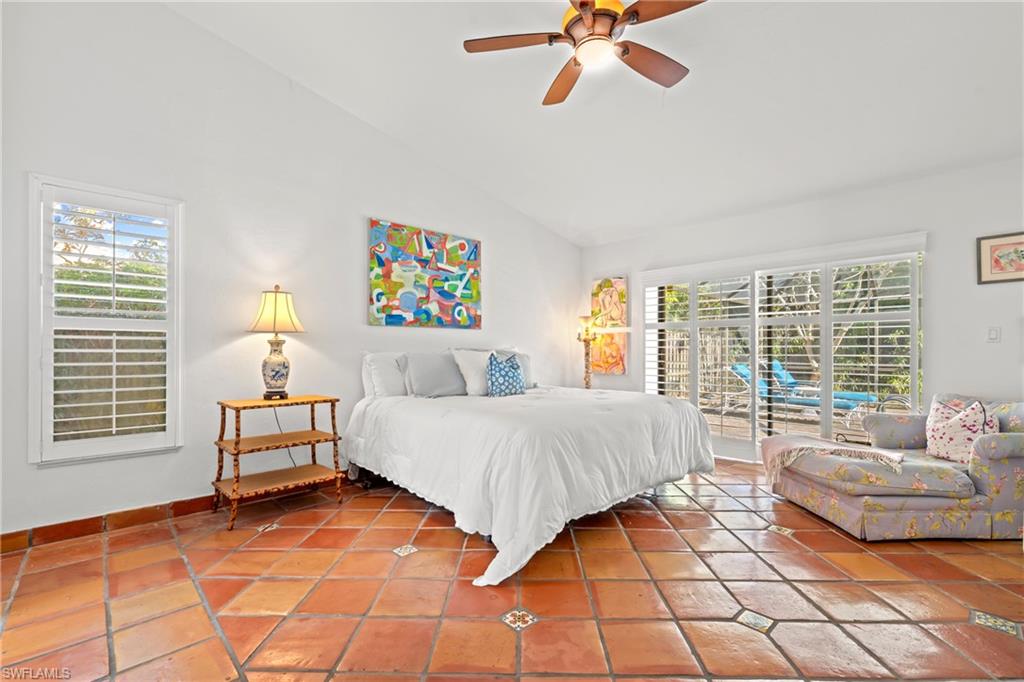 2419 Pinewoods Circle, Unit 11 Naples, FL 34105 - Photo 20 of 32 a spacious bedroom with a bed and a couch