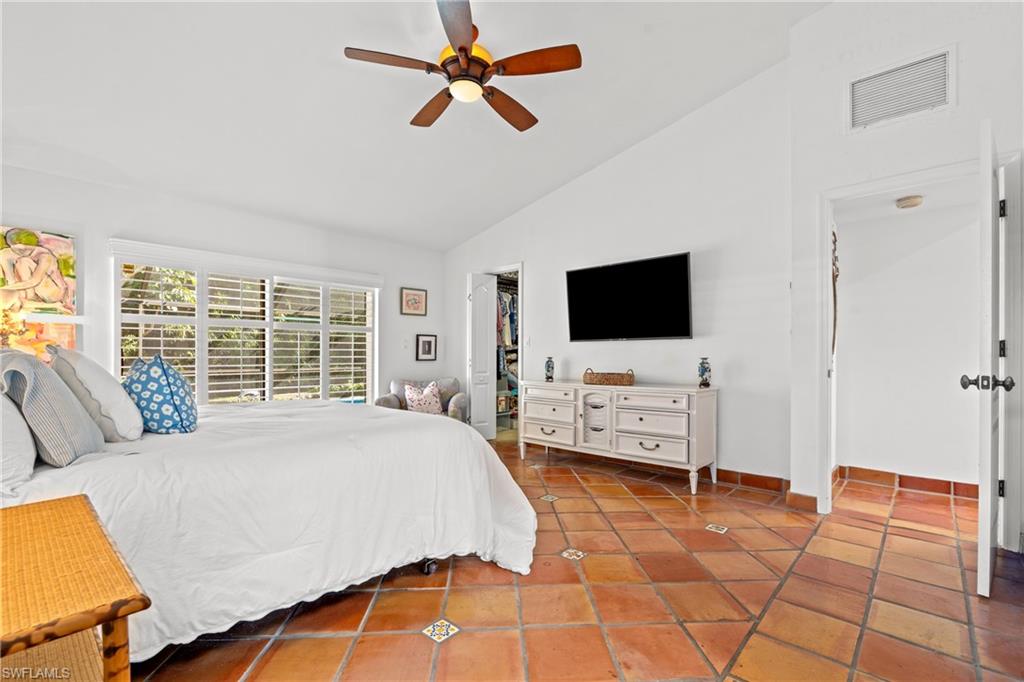 2419 Pinewoods Circle, Unit 11 Naples, FL 34105 - Photo 21 of 32 a bedroom with a bed and a flat screen tv