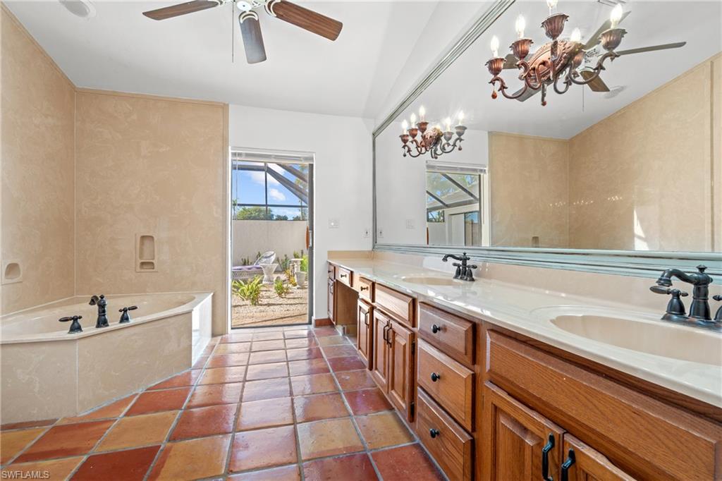 2419 Pinewoods Circle, Unit 11 Naples, FL 34105 - Photo 22 of 32 a spacious bathroom with a double vanity sink a mirror and a bathtub