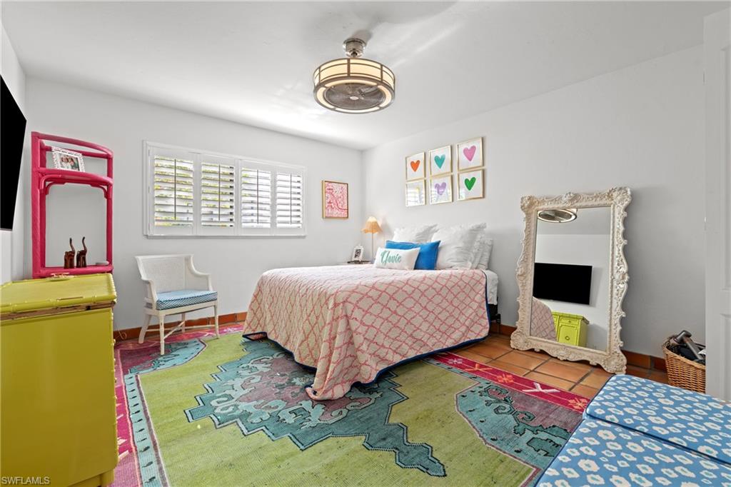 2419 Pinewoods Circle, Unit 11 Naples, FL 34105 - Photo 23 of 32 a bedroom with a bed and a table in it