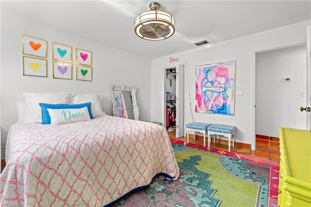 2419 Pinewoods Circle, Unit 11 Naples, FL 34105 - Photo 24 of 32 a bedroom with bed and wall paintings