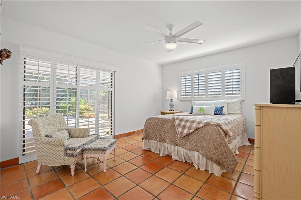 2419 Pinewoods Circle, Unit 11 Naples, FL 34105 - Photo 26 of 32 a bedroom with a bed and a large window