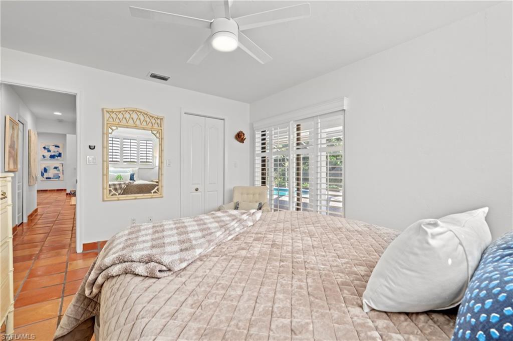 2419 Pinewoods Circle, Unit 11 Naples, FL 34105 - Photo 27 of 32 a bedroom with a large bed and a couch