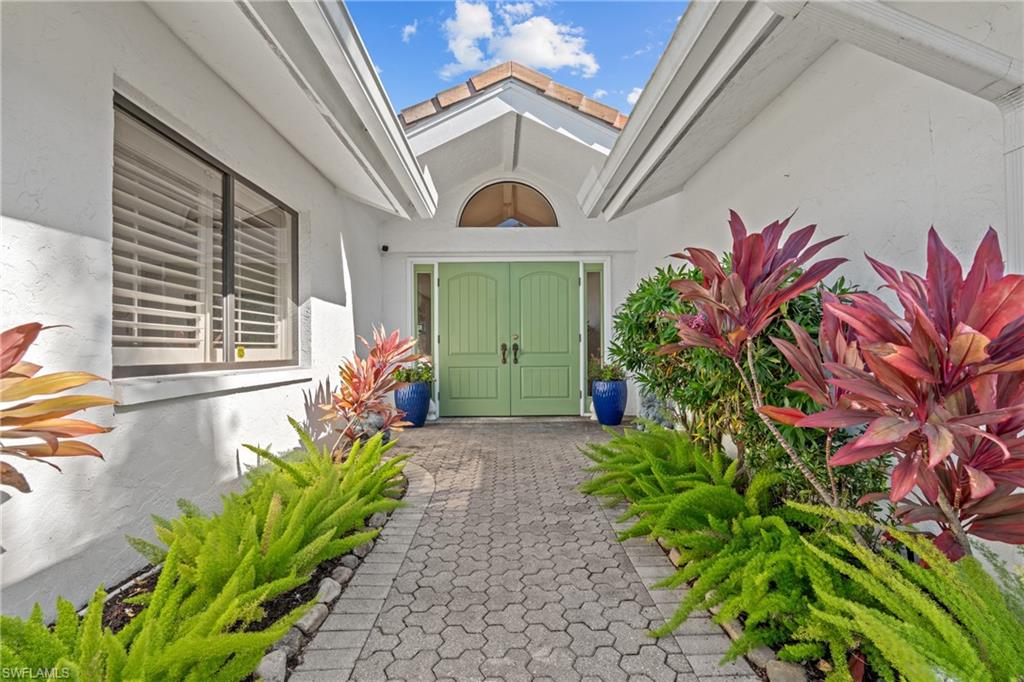 2419 Pinewoods Circle, Unit 11 Naples, FL 34105 - Photo 3 of 32 a front view of a house with a lot of flower plants