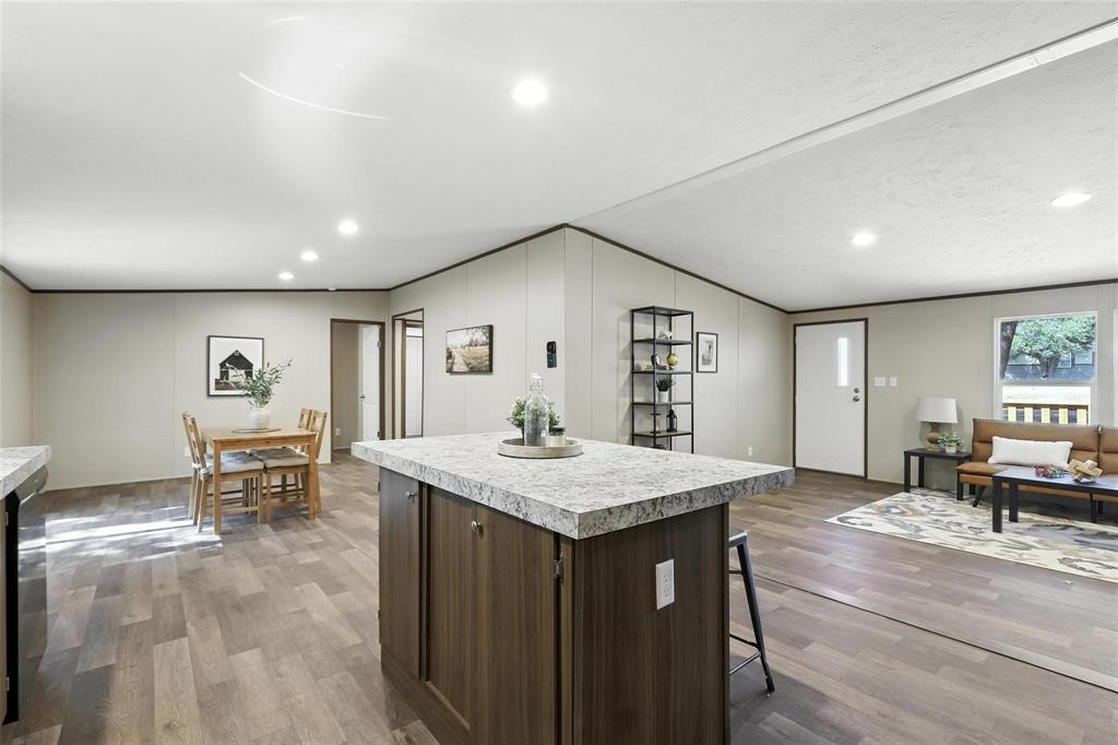 131 Kelly Court Azle, TX 76020 - Photo 11 of 22 a view of kitchen island a sink wooden floor and a dining table chair
