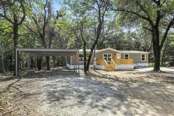 a view of a house with a yard and large tree