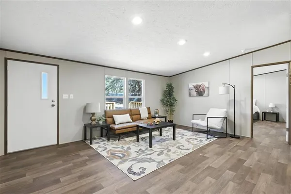 a living room with furniture a wooden floor and next to a window