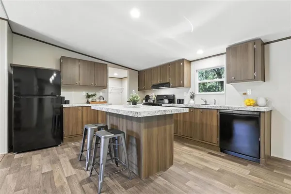 a kitchen with a sink refrigerator and cabinets