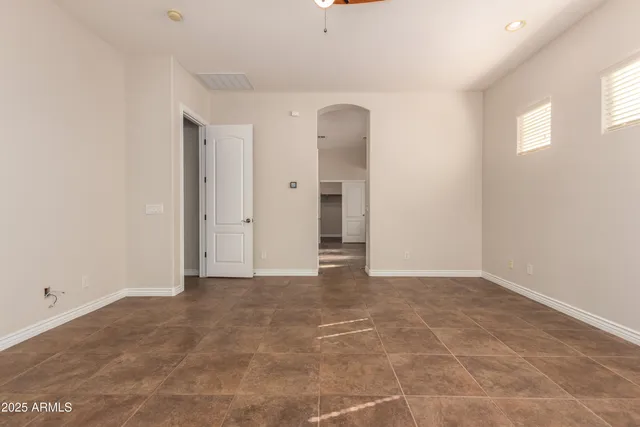 a view of an empty room with window and closet area