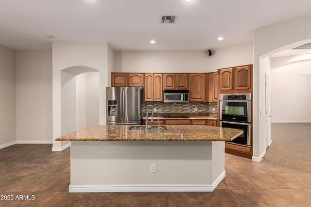 a kitchen with stainless steel appliances granite countertop a stove and a refrigerator