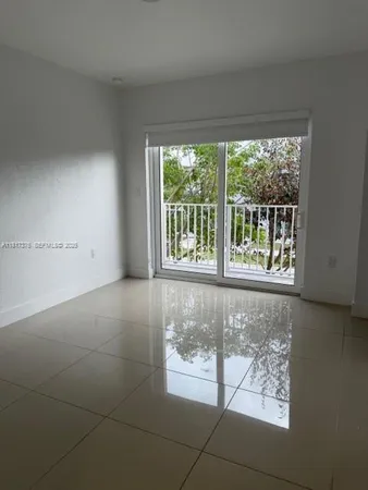 a view of a room with a large window and wooden floor