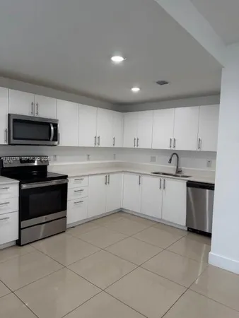 a kitchen with a stove sink and cabinets