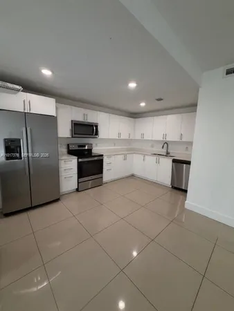 a large kitchen with a cabinets and stainless steel appliances