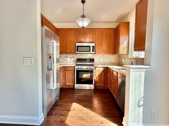 a kitchen with wooden floors and stainless steel appliances
