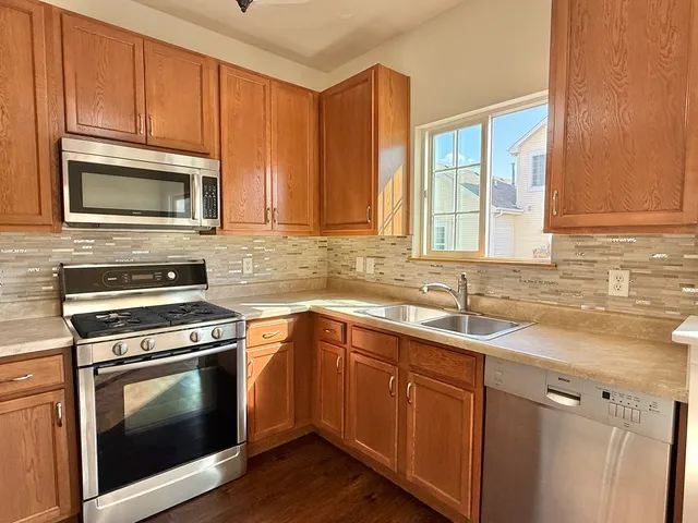 a kitchen with granite countertop cabinets stainless steel appliances and a sink