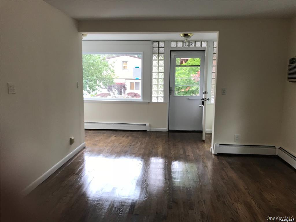 44 Graywood Road, Unit 2 Port Washington, NY 11050 - Photo 2 of 17 an empty room with wooden floor and windows