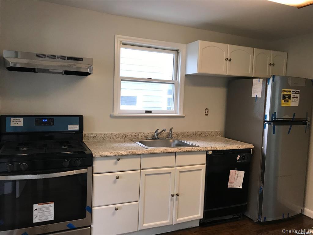 44 Graywood Road, Unit 2 Port Washington, NY 11050 - Photo 3 of 17 a kitchen with a sink stove and refrigerator