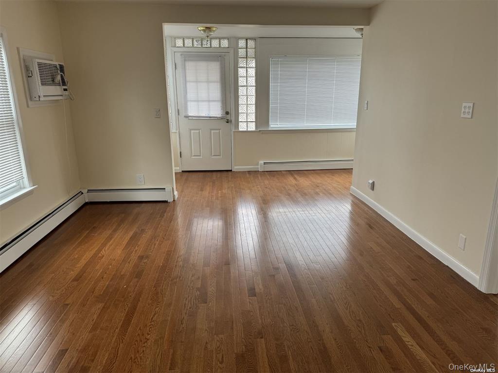 44 Graywood Road, Unit 2 Port Washington, NY 11050 - Photo 6 of 17 an empty room with wooden floor and windows