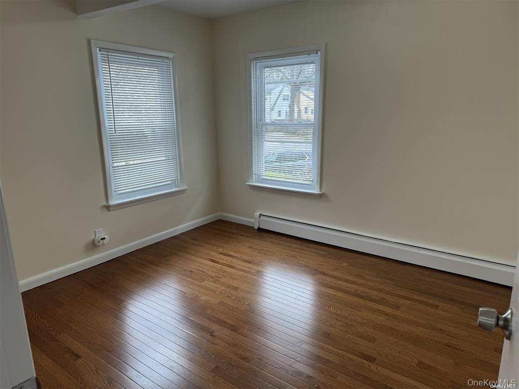 44 Graywood Road, Unit 2 Port Washington, NY 11050 - Photo 8 of 17 an empty room with wooden floor and windows