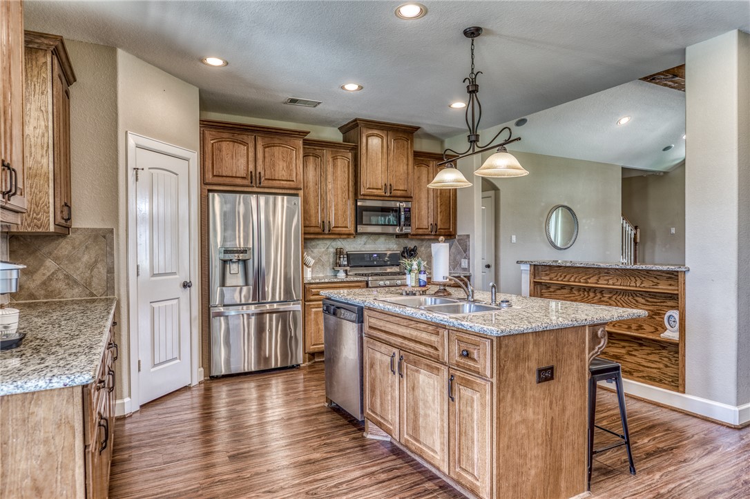 586 Ruby Drive Bellville, TX 77418 - Photo 15 of 50 a kitchen with stainless steel appliances granite countertop a sink a stove and a wooden floors