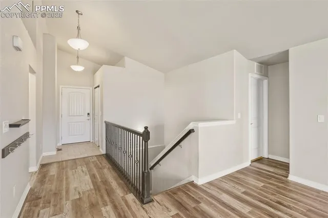 a view of a hallway with wooden floor and staircase