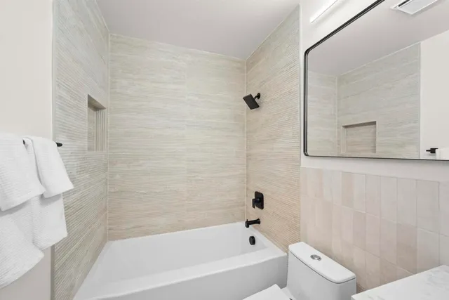 a bathroom with a toilet a sink and mirror