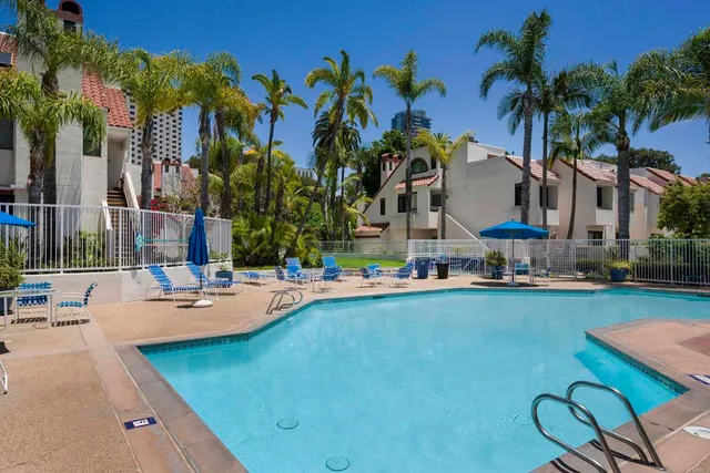 a swimming pool with outdoor seating and a garden