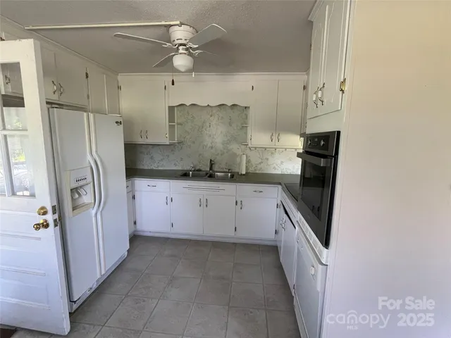 a kitchen with granite countertop a refrigerator and a sink
