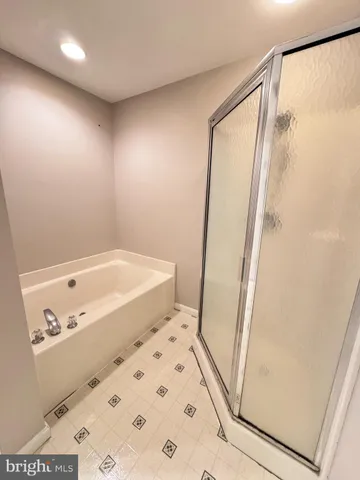 an empty room with a chandelier fan and windows