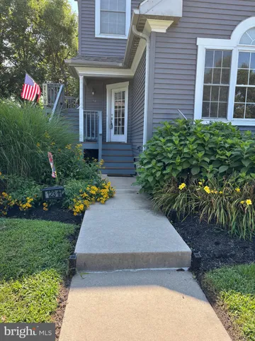 a front view of a house with a yard and potted plants
