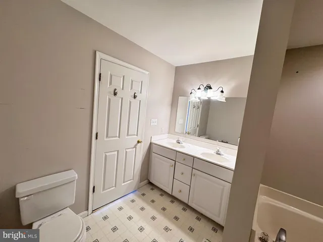 an empty room with closet and a chandelier fan