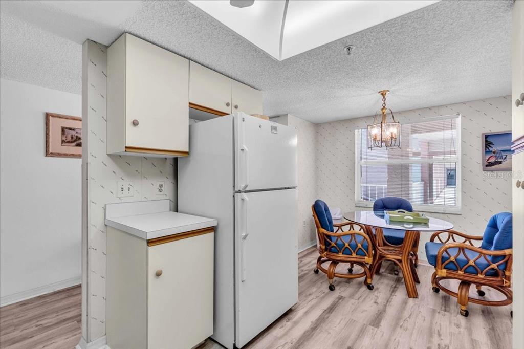 6501 Stone River Road, Unit 209 Bradenton, FL 34203 - Photo 12 of 45 a kitchen with stainless steel appliances granite countertop a dining table chairs refrigerator and sink