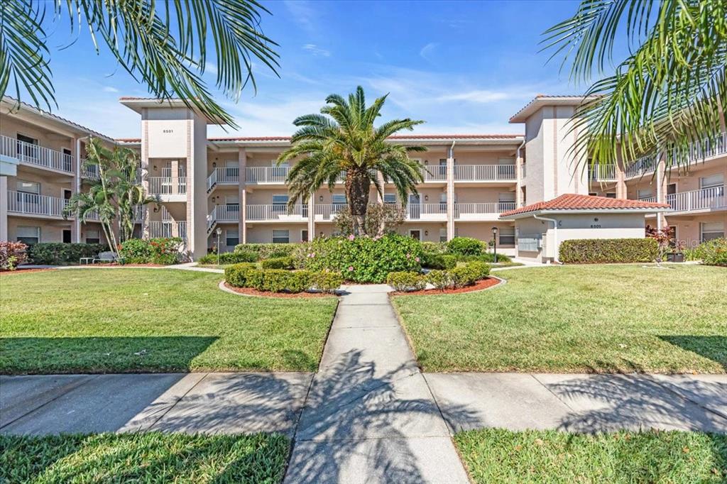 6501 Stone River Road, Unit 209 Bradenton, FL 34203 - Photo 2 of 45 a white house with a yard and potted plants
