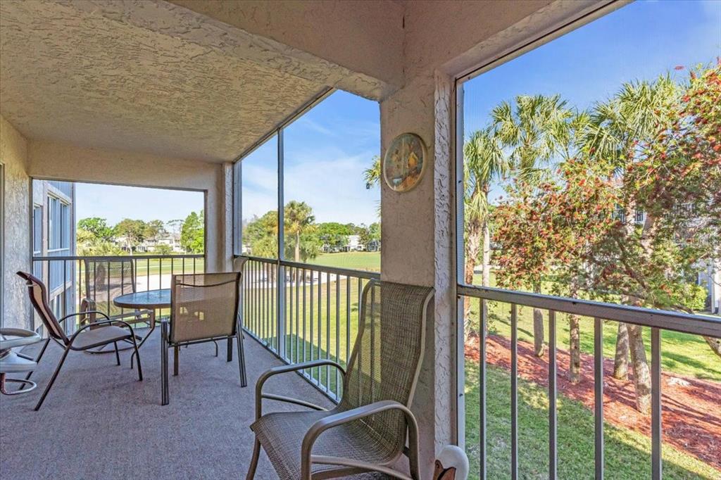 6501 Stone River Road, Unit 209 Bradenton, FL 34203 - Photo 4 of 45 a view of a porch with furniture and floor to ceiling window