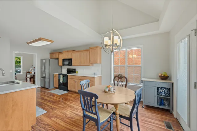 a view of a dining room with furniture a chandelier and wooden floor
