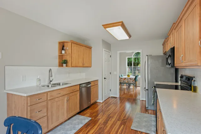 a kitchen with wooden floors and white cabinets