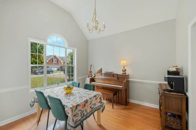 a view of a dining room with furniture a chandelier and wooden floor