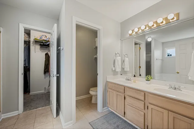 a spacious bathroom with a double vanity sink mirror and toilet