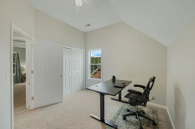 a view of a workspace with furniture and a window