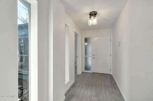 a view of a hallway with wooden floor and kitchen