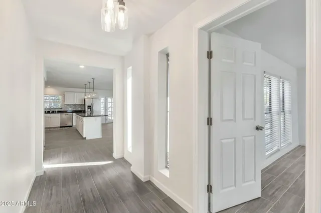 a kitchen with stainless steel appliances granite countertop a sink a island with wooden floor and cabinets