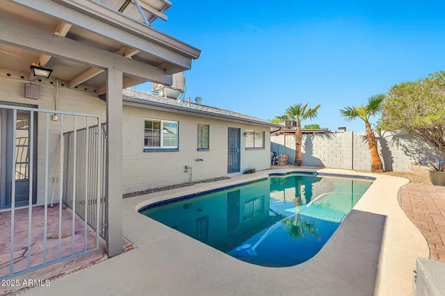 a view of backyard with table and chairs and wooden fence